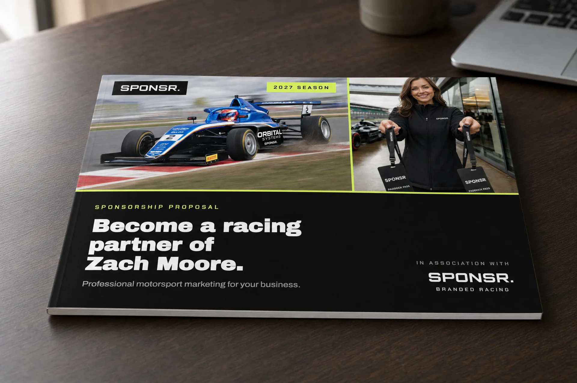 A bound SPONSR sponsorship proposal lying on a desk, its cover carrying a single-seater racing car and the title 'Become a racing partner of Zach Moore' (concept imagery; Zach Moore is not a real driver).